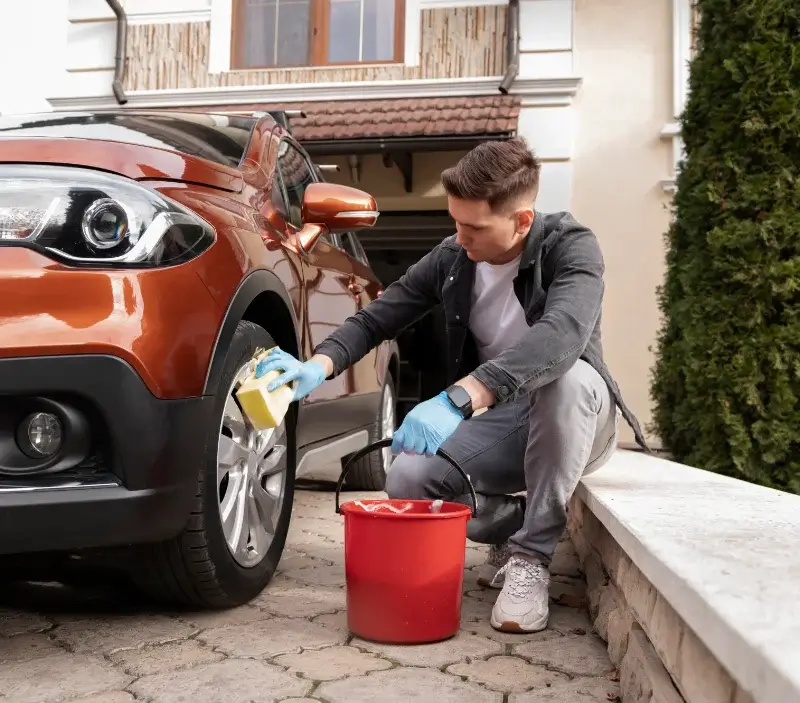 Lavage auto à domicile Moulins-la-Marche : professionnel intervenant sur un véhicule
